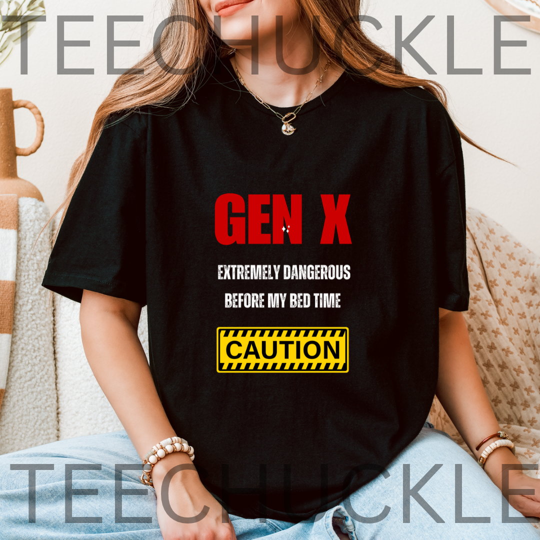 A woman wearing a black graphic t-shirt with red, white, and yellow text that reads 'GEN X EXTREMELY DANGEROUS BEFORE MY BED TIME CAUTION'. The image has a watermark overlay reading 'TEECHUCKLE'.