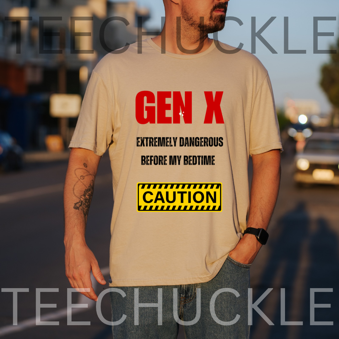 A man wearing a sand graphic t-shirt with red and black text reading 'GEN X EXTREMELY DANGEROUS BEFORE MY BEDTIME' and a yellow caution box graphic, set against a blurred street background.