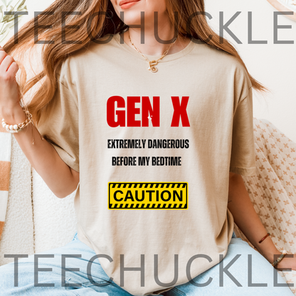 A woman wearing a sand graphic t-shirt with a red and black text design reading 'GEN X EXTREMELY DANGEROUS BEFORE MY BEDTIME' and a yellow caution box. 