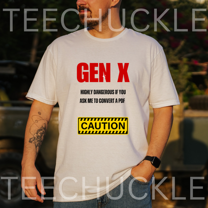 A white graphic t-shirt . The shirt features the text 'GEN X' in bold red letters, followed by 'HIGHLY DANGEROUS IF YOU ASK ME TO CONVERT A PDF' in black, and a yellow 'CAUTION' warning label graphic.
