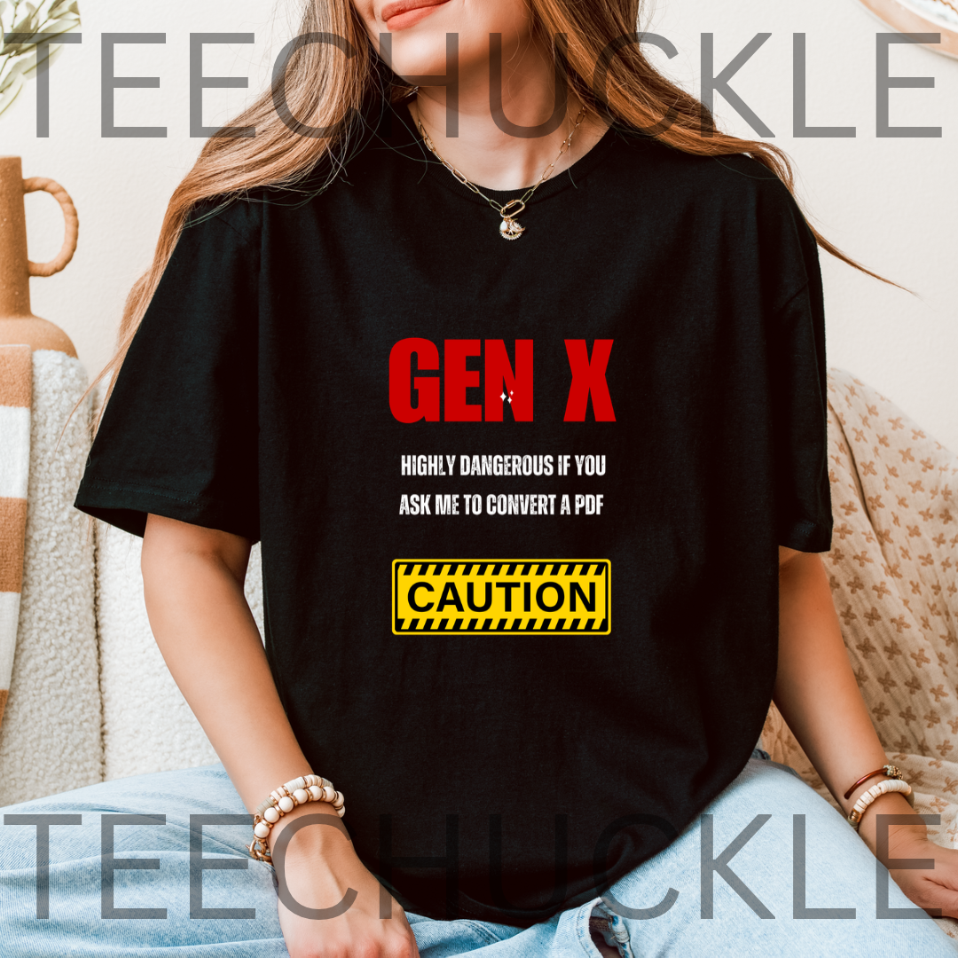 A woman wearing a black graphic T-shirt with red and white text reading 'GEN X' and a yellow caution-style box below, seated indoors on a patterned couch. 