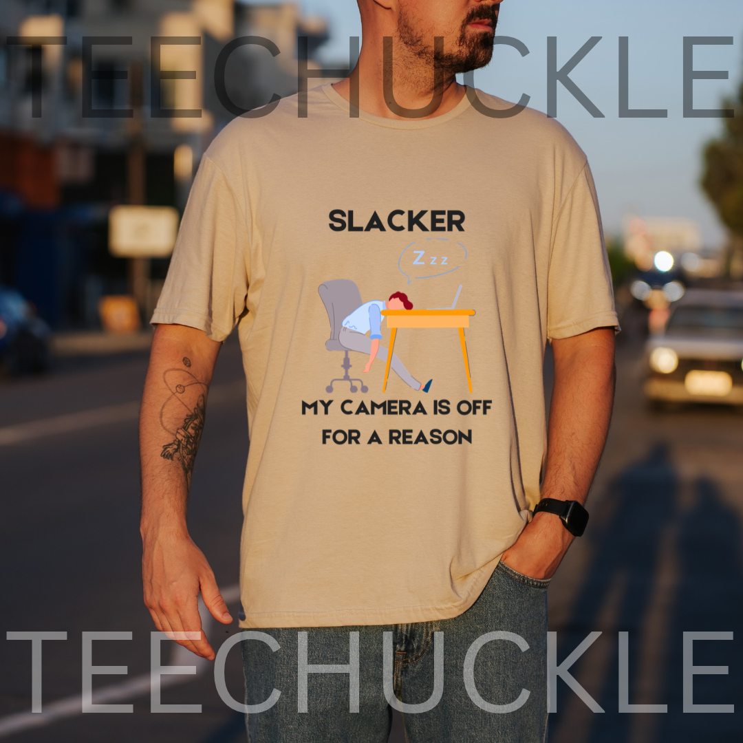A sand graphic t-shirt  featuring a cartoon illustration of a person sleeping at a desk with the text 'SLACKER, MY CAMERA IS OFF FOR A REASON'. 