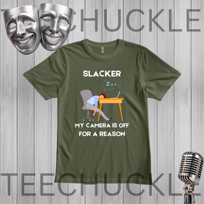A green graphic t-shirt featuring a sleeping office worker at a desk with the text 'EXHAUSTED I'M NOT SLACKING I'M JUST CHARGING'. The t-shirt is displayed on a gray wood-plank background with a silver microphone, comedy masks