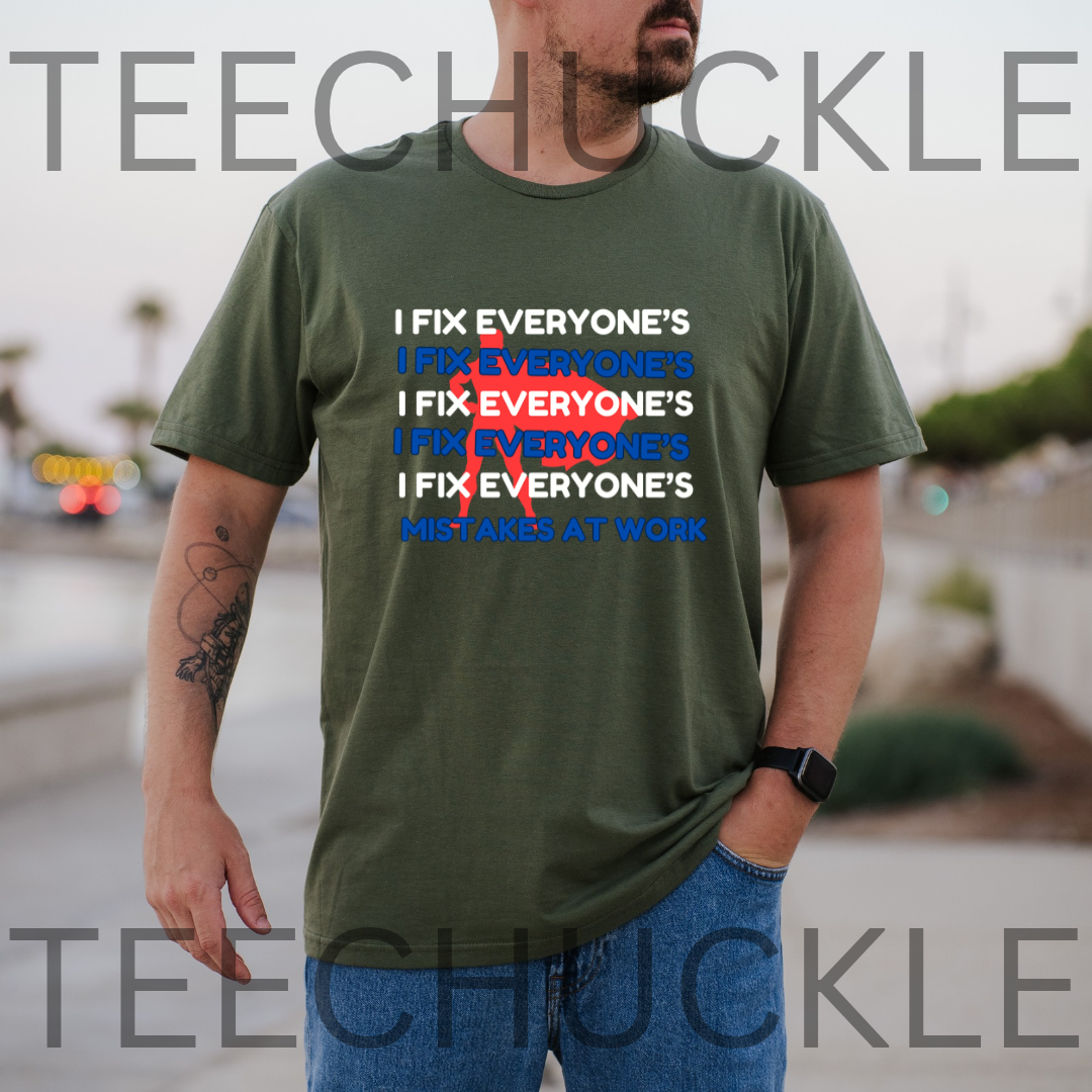 A green graphic t-shirt, featuring a text design that reads 'I FIX EVERYONE'S MISTAKES AT WORK' with a red scribble over repeated 'I FIX EVERYONE'S' lines. 