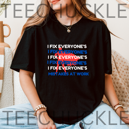 A woman wearing a black graphic t-shirt with the slogan 'I FIX EVERYONE'S MISTAKES AT WORK' printed in white and blue, with a red scribble graphic. T