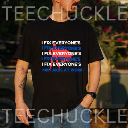 A man wearing a black graphic t-shirt with the slogan 'I FIX EVERYONE'S MISTAKES AT WORK' printed in white and blue. The shirt features a red 'NO' graphic overlay.