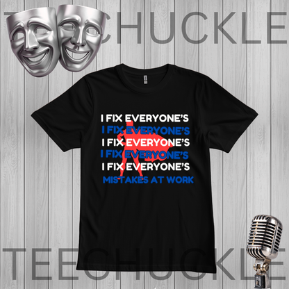 A black graphic t-shirt displayed against a gray wood-plank background. The shirt features a white and blue text design that reads 'I FIX EVERYONE'S MISTAKES AT WORK' crossed out in red.