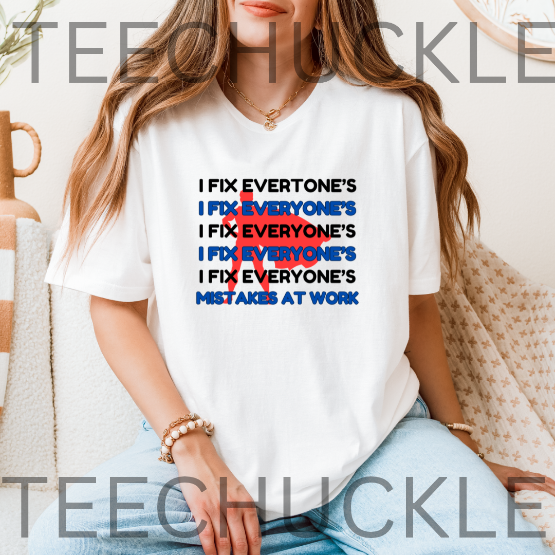 A woman wearing a white graphic t-shirt with a text design that reads 'I FIX EVERYONE'S I FIX EVERYONE'S I FIX EVERYONE'S I FIX EVERYONE'S I FIX EVERYONE'S MISTAKES AT WORK' in black and blue, with a red 'X' crossed over the repeated lines.