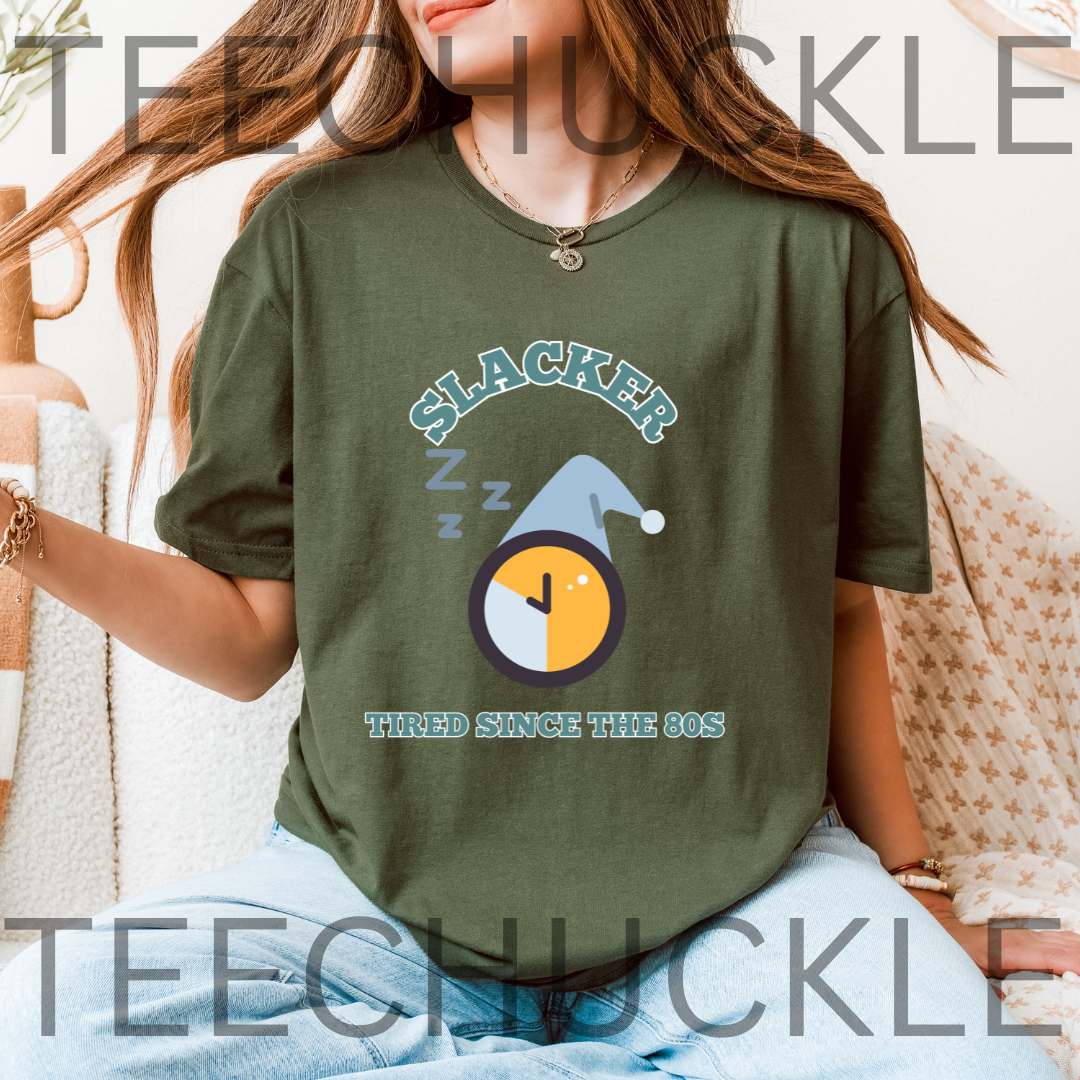 A woman wearing a green graphic t-shirt with a 'Slacker' clock design, paired with light blue jeans. 