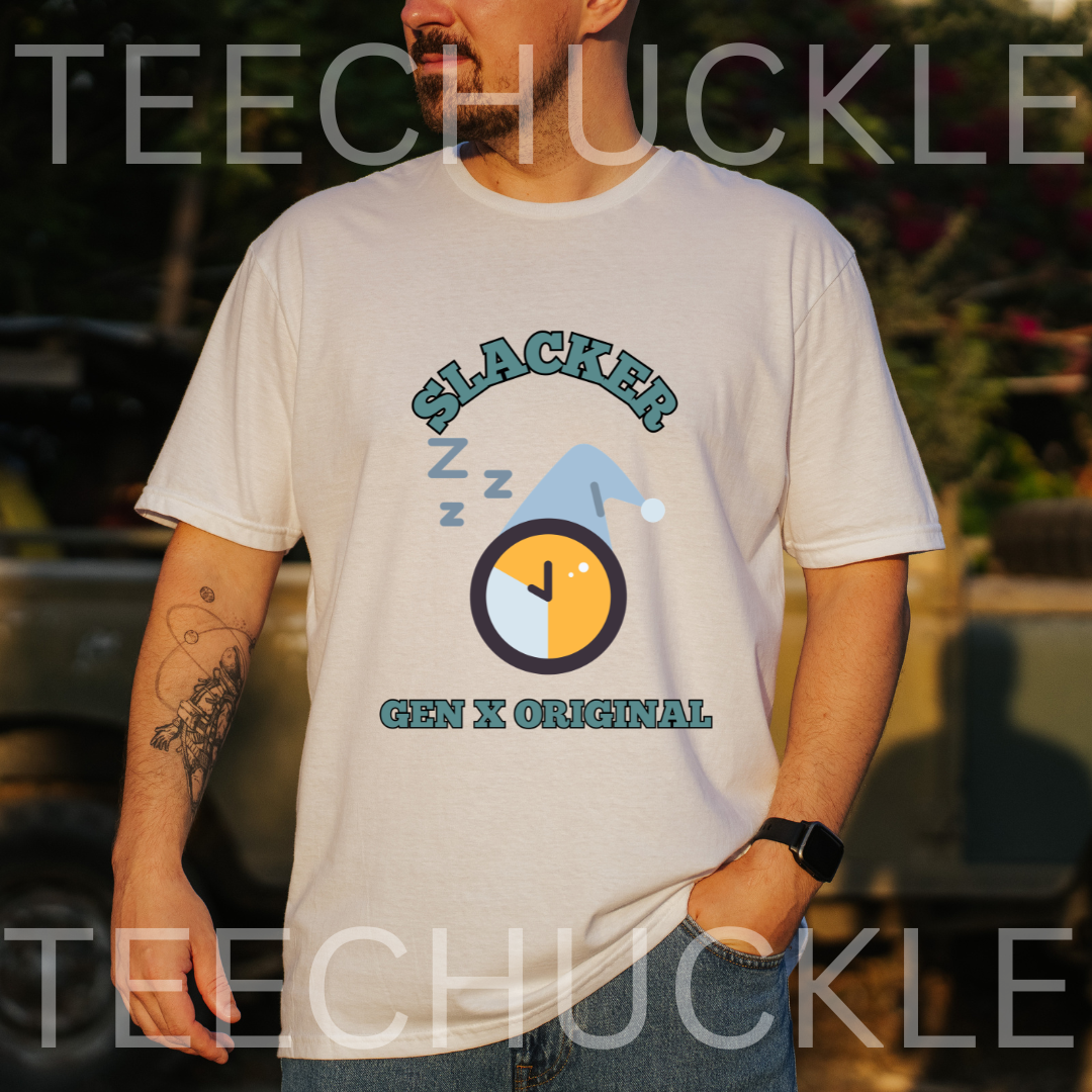 A man wearing a white graphic t-shirt with a 'Slacker' clock and hat design, set against a blurred outdoor background.