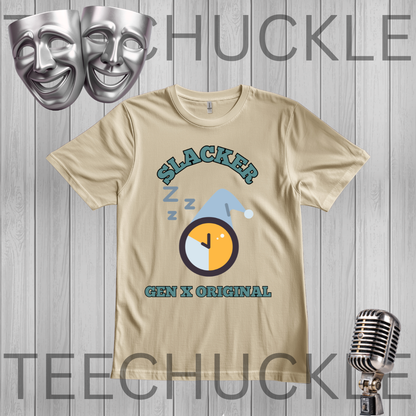 A sand graphic t-shirt featuring a 'Slacker Gen X Original' design with a clock and z-z-z icons, displayed on a gray wood plank background with theatrical masks and a vintage microphone. 