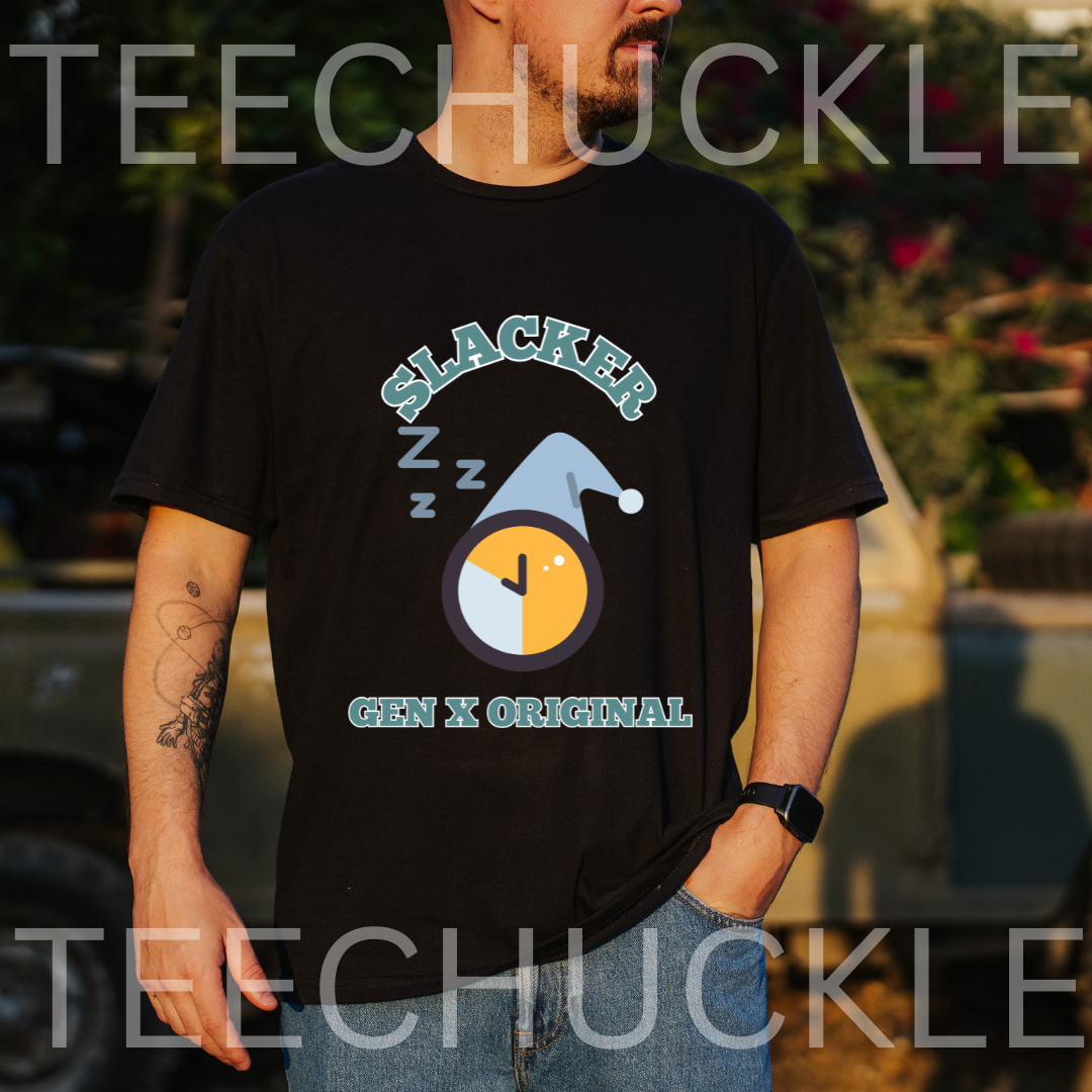 A man wearing a black graphic t-shirt with a 'Slacker' clock and hat design, set against an outdoor blurred background.