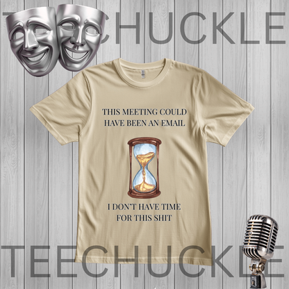 A sand graphic t-shirt displayed on a gray wood plank background, featuring a humorous meeting procrastination quote and an hourglass illustration. there is theatrical masks and a vintage microphone n background