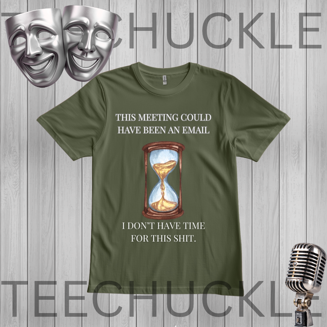 A green graphic t-shirt featuring a humorous quote about meetings and an hourglass illustration, displayed on a gray wood plank background with theatrical masks and a vintage microphone.