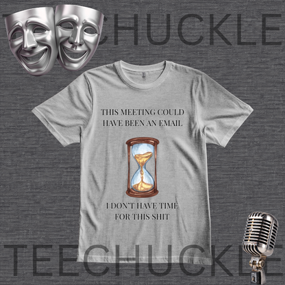 A gray graphic t-shirt featuring a humorous meeting-related quote and an hourglass illustration. The t-shirt is displayed on a dark gray textured background with theatrical comedy and tragedy masks in the top-left corner and a vintage microphone in the bottom-right corner.