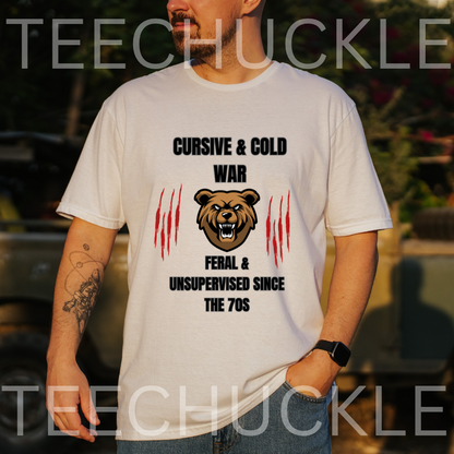 A man wearing a white graphic t-shirt with a bear design and the text 'CURSIVE & COLD WAR FERAL & UNSUPERVISED SINCE THE 70S'. 