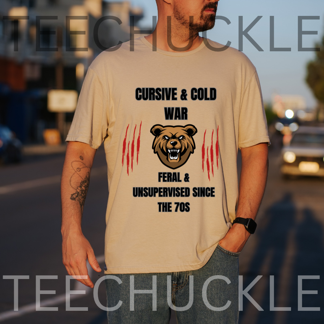 A man wearing a graphic t-shirt with a bear design and the text 'CURSIVE & COLD WAR FERAL & UNSUPERVISED SINCE THE 70S' in black and red, set against a blurred street background.