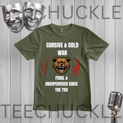A green graphic t-shirt displayed on a gray wood-plank background. The shirt features a design with a brown bear head, red claw marks, and white text reading 'CURSIVE & COLD WAR FERAL & UNSUPERVISED SINCE THE 70S'.
