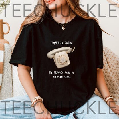 A woman wearing a black graphic t-shirt with a vintage rotary phone illustration and the text 'Tangled Coils My Privacy Was A 20 Foot Cord'. 