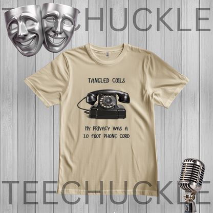 A sand graphic t-shirt featuring a black rotary telephone and the text 'Tangled Coils' and 'My Privacy Was A 20 Foot Phone Cord' on a gray wood-plank background, and styled with comedy masks and a vintage microphone.