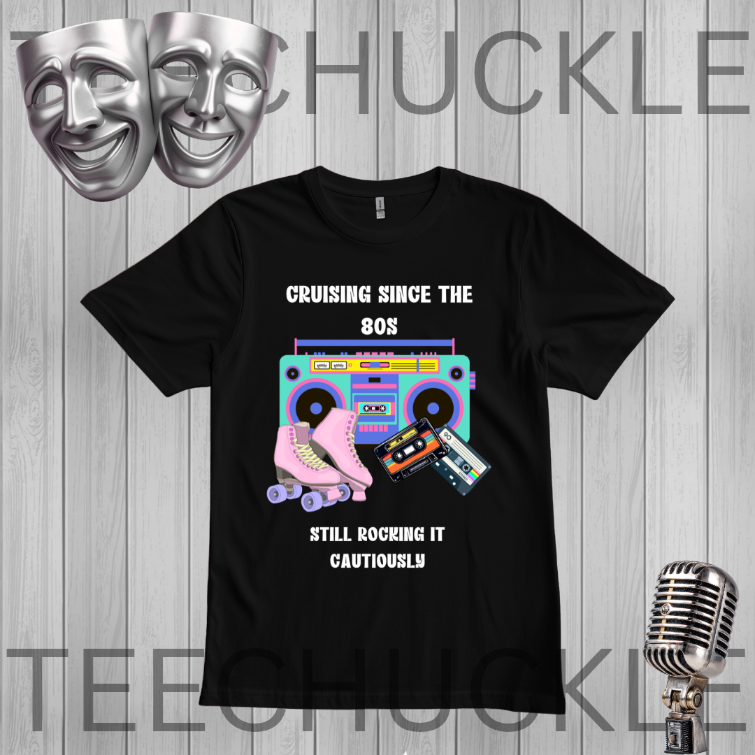 A black short-sleeve graphic T-shirt laid flat on a gray wood-plank background. The shirt features white text reading 'CRUISING SINCE THE 80S' above a retro boombox, pink roller skate, cassette tape, and speaker illustration, with 'STILL ROCKING IT CAUTIONOUSLY' below.