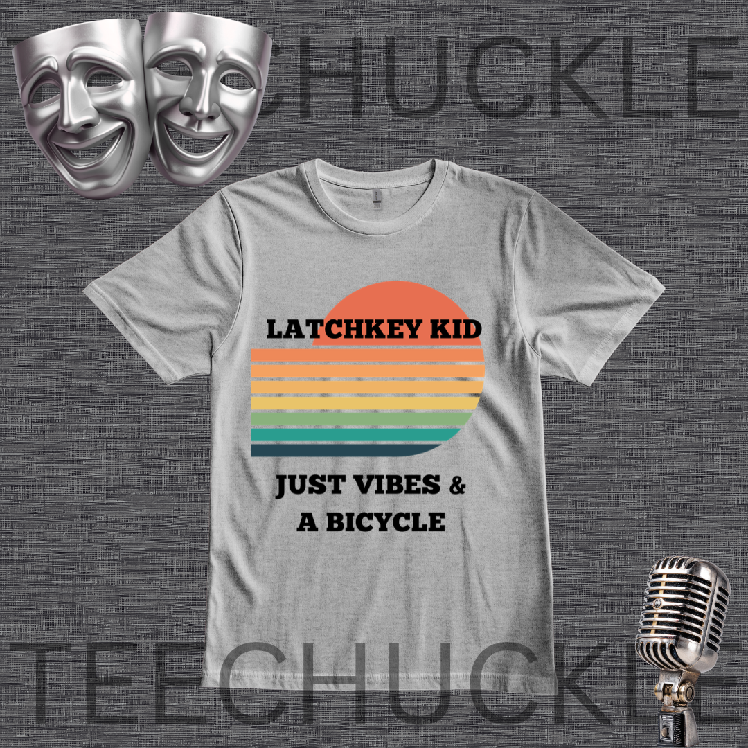 A gray graphic t-shirt displayed on a dark gray textured background. The shirt features a retro sunset graphic with orange, yellow, and green stripes, and the text 'LATCHKEY KID JUST VIBES & A BICYCLE'.