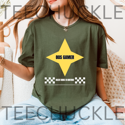 A woman wearing a green graphic t-shirt with a yellow star and the text '80S GAMER' and 'INSERT GOINS TO CONTINUE' on the front, paired with light blue jeans. 