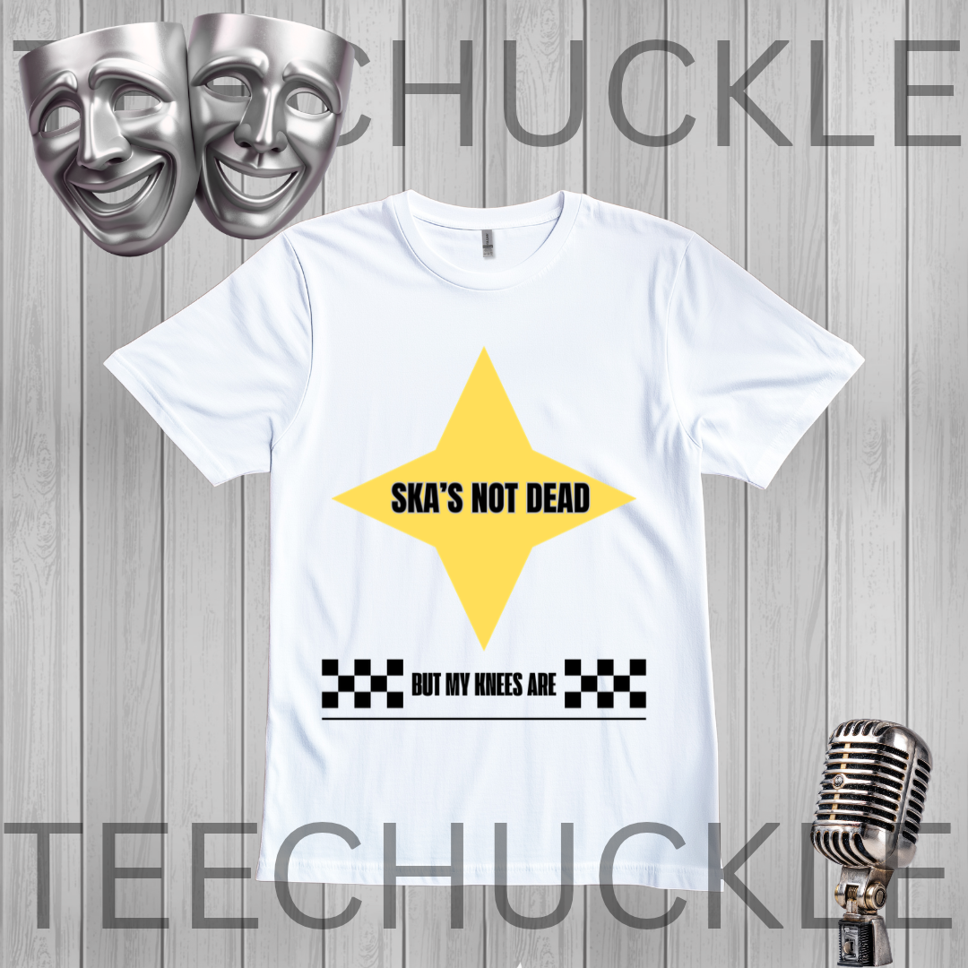 A white short-sleeve graphic T-shirt. The shirt has a large yellow star shape with the text 'SKA'S NOT DEAD' in black, plus a black-and-white checkered bar and the phrase 'BUT MY KNEES ARE' below.