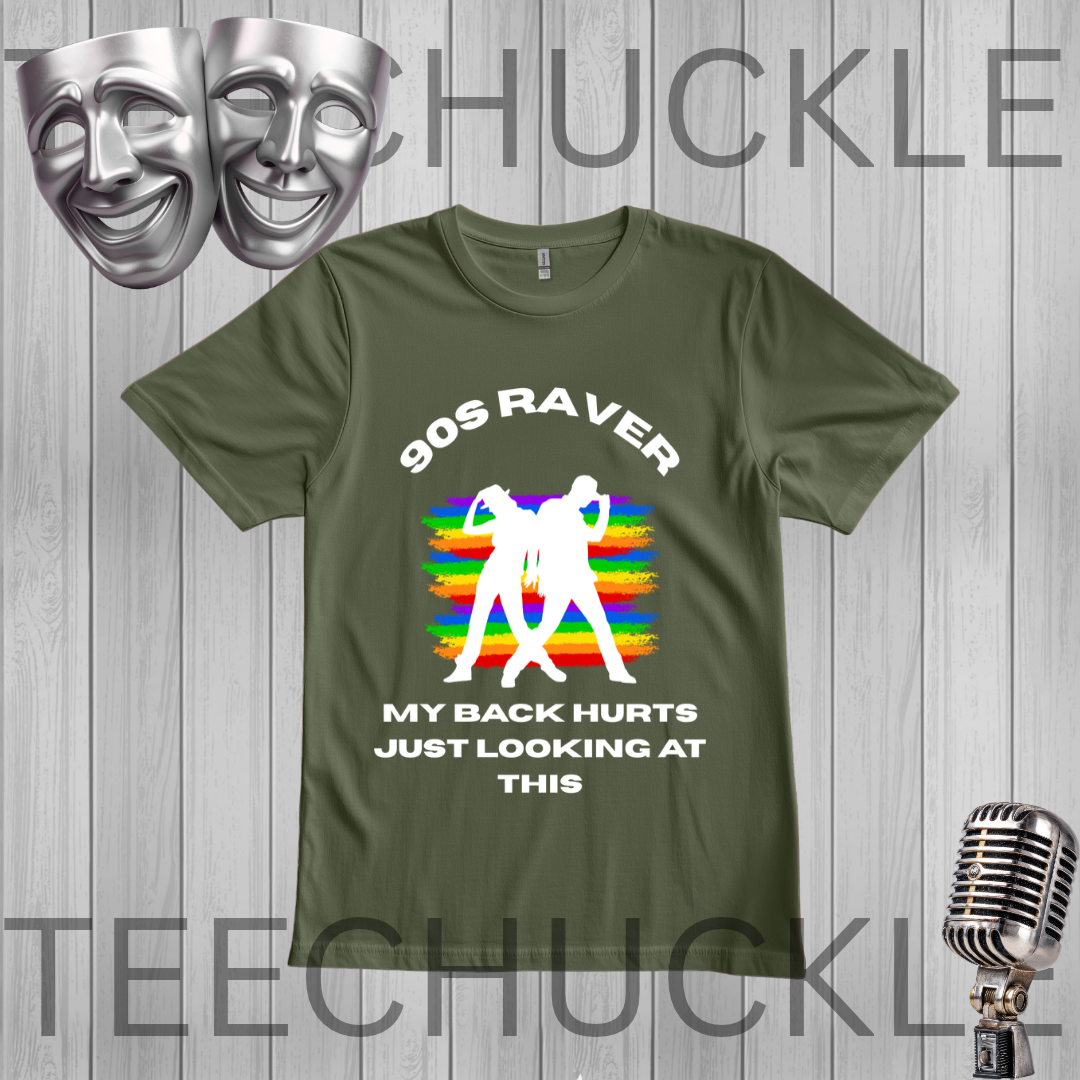 A green graphic t-shirt displayed on a gray wood plank background. The shirt features a white graphic of two silhouettes dancing in front of a retro rainbow-striped microphone stand, with the text '90S RAVER MY BACK HURTS JUST LOOKING AT THIS'.