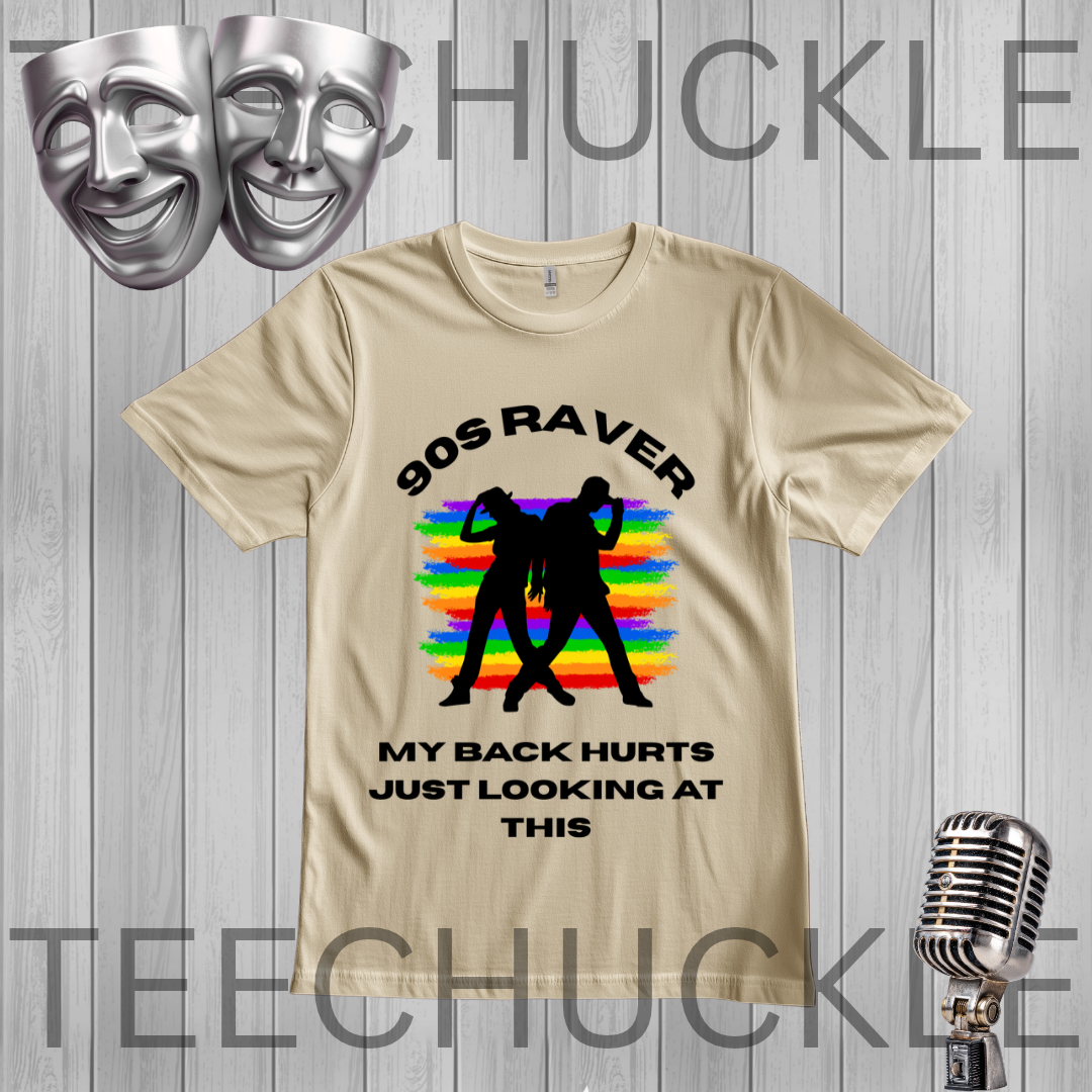 A sand graphic t-shirt displayed on a gray wood-plank background. The shirt features a black graphic of two silhouettes dancing in front of a rainbow-striped background, with the text '90S RAVER' above and 'MY BACK HURTS JUST LOOKING AT THIS' below.