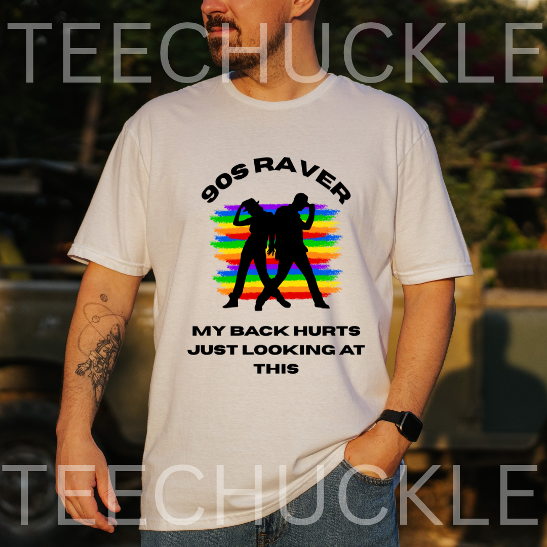 A man wearing a white graphic t-shirt with a '90s Raver' design featuring black silhouettes and a rainbow stripe background, with the text 'MY BACK HURTS JUST LOOKING AT THIS'.