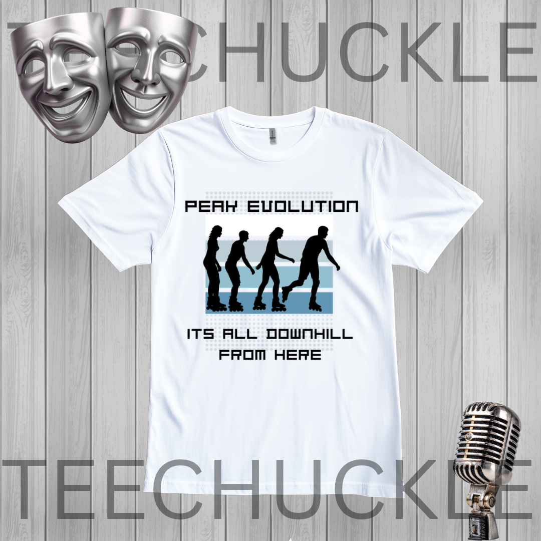 A white graphic t-shirt displayed on a gray wood-plank background, featuring a 'Peak Evolution' design with black silhouettes of figures walking downhill and the text 'ITS ALL DOWNHILL FROM HERE'. The shirt is framed by silver theater masks in the top-left and a vintage microphone in the bottom-right