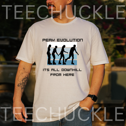 A man wearing a white graphic t-shirt with a black and blue 'Peak Evolution' downhill silhouette design, set against a blurred outdoor background 