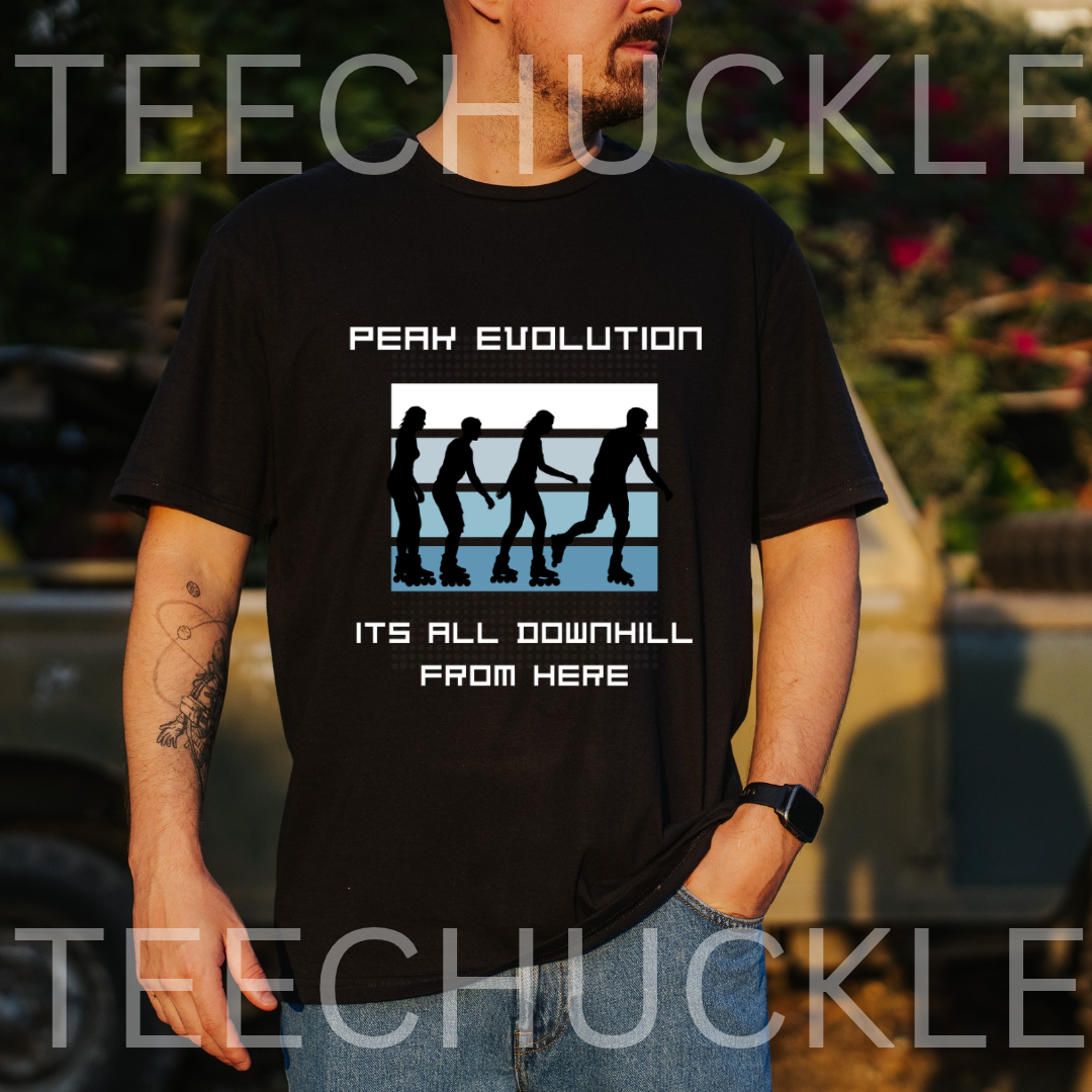 A man wearing a black graphic t-shirt with a white and blue 'Peak Evolution' downhill silhouette design, set against an outdoor blurred background 
