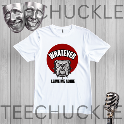 A white short-sleeve graphic t-shirt displayed on a gray wood plank background, featuring a red circular graphic with a bulldog and the text 'WHATEVER LEAVE ME ALONE'. The image includes decorative props like silver theater masks and a vintage microphone