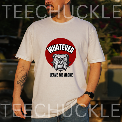A man wearing a white graphic t-shirt with a red circular bulldog design and the text 'WHATEVER LEAVE ME ALONE'. and is taken in an outdoor setting.