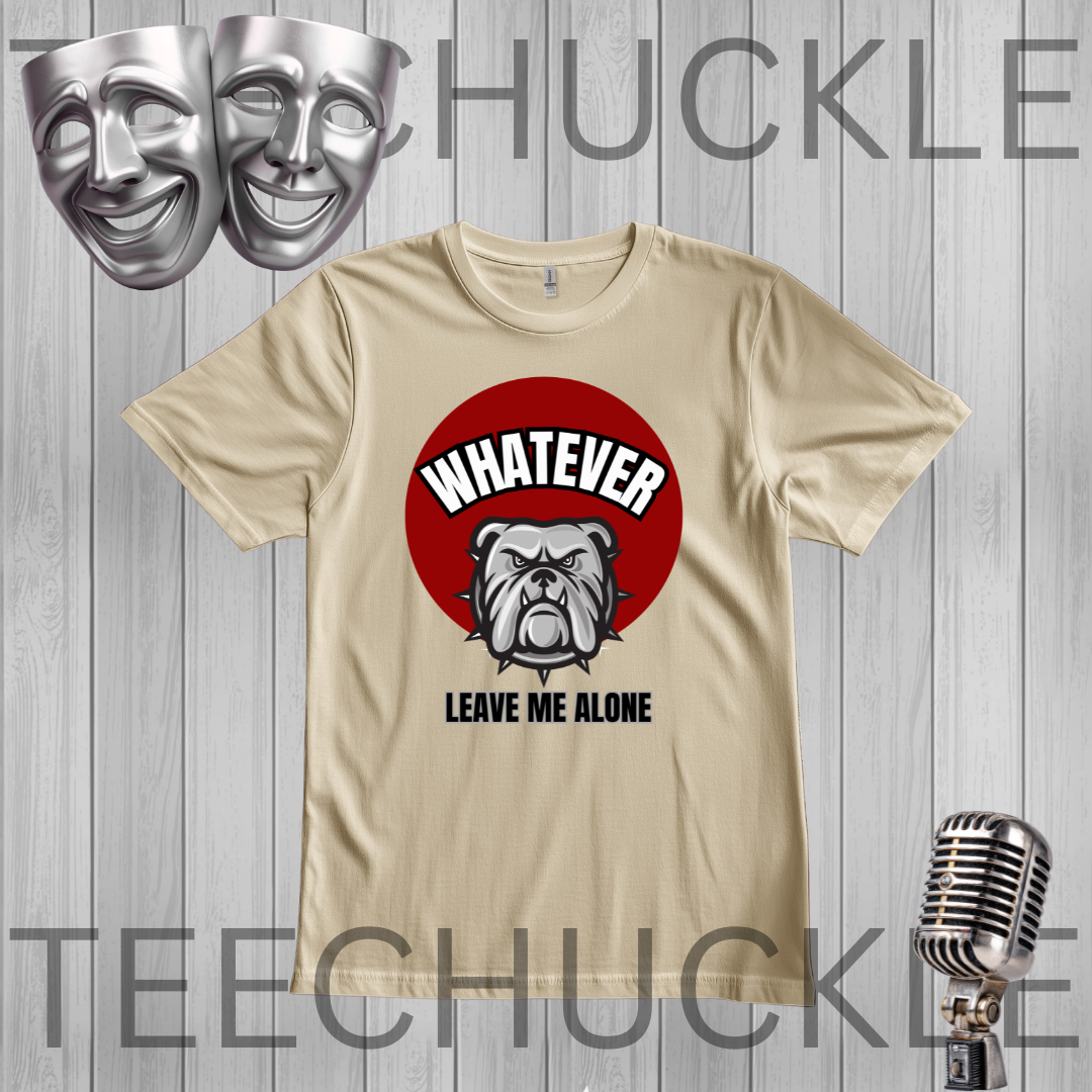 A graphic t-shirt featuring a red circle with a bulldog illustration and the text 'WHATEVER LEAVE ME ALONE'. The t-shirt is displayed on a gray wood plank background with a silver microphone and two silver comedy masks,