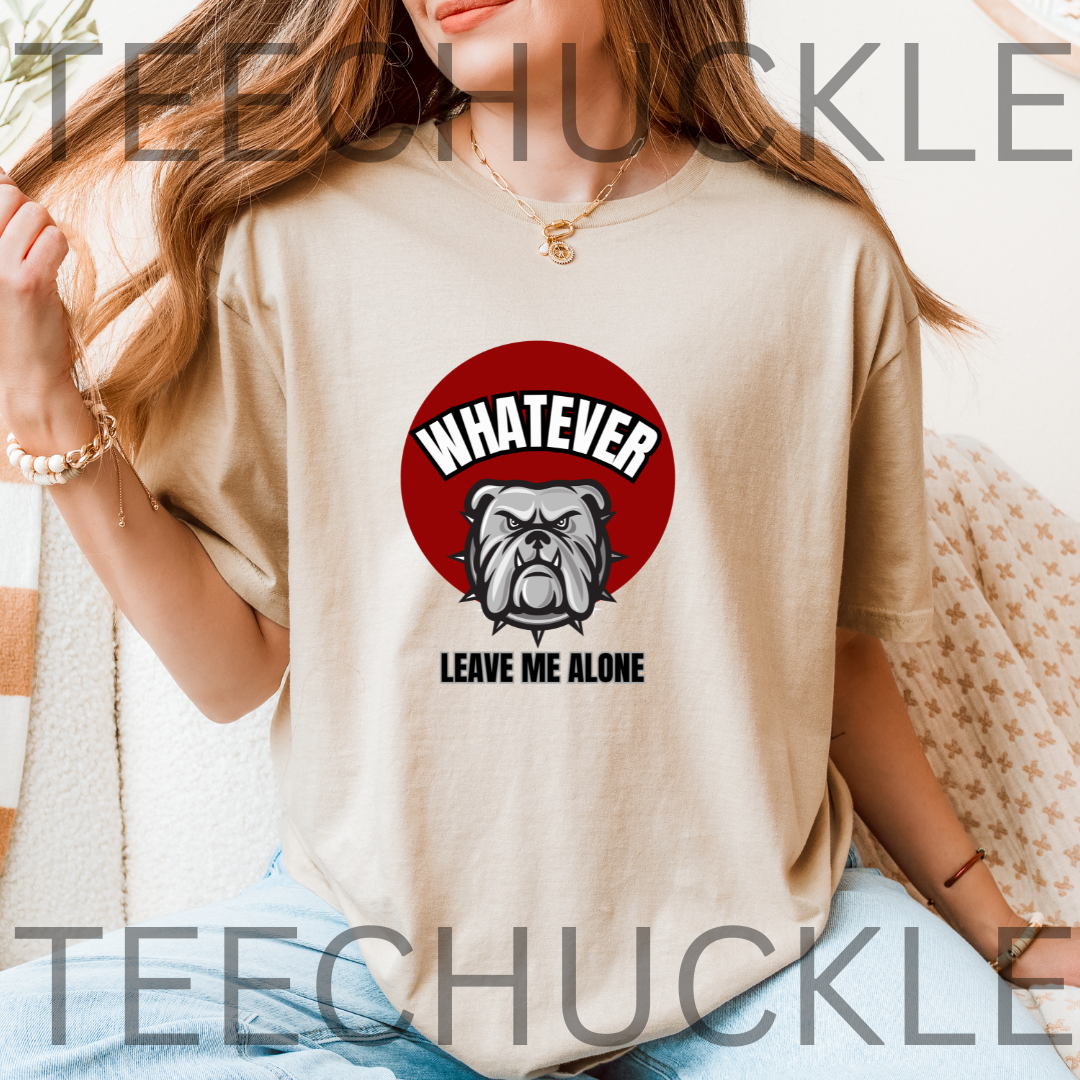 A woman wearing a sand graphic t-shirt with a red circle containing a bulldog illustration and the text 'WHATEVER LEAVE ME ALONE'. 
