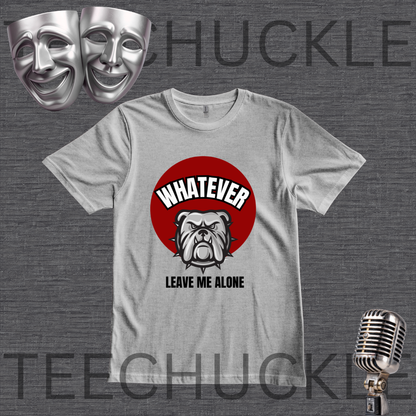 A gray graphic t-shirt displayed on a dark gray textured background, featuring a red circular graphic with a bulldog illustration and the text 'WHATEVER LEAVE ME ALONE'. The image includes decorative props like silver theater masks and a vintage microphone