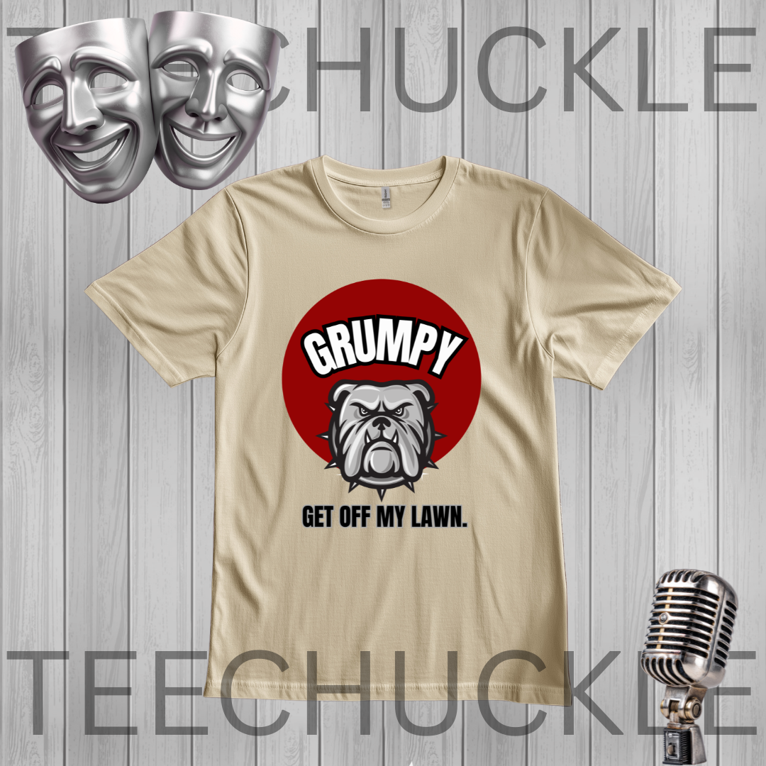 A sand graphic t-shirt featuring a red circle with a bulldog and the text 'GRUMPY GET OFF MY LAWN.' displayed on a gray wood plank background with theatrical masks, a vintage microphone, 