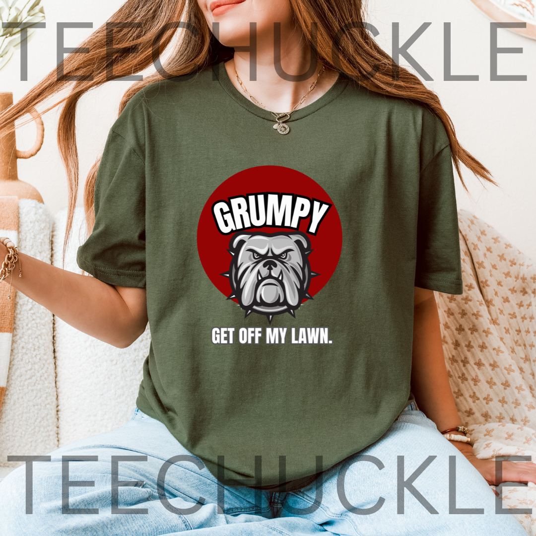 A woman wearing a green graphic t-shirt with a red circular bulldog design and the text 'GRUMPY GET OFF MY LAWN.' 