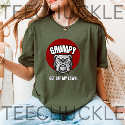 A woman wearing a green graphic t-shirt with a red circular bulldog design and the text 'GRUMPY GET OFF MY LAWN.' 