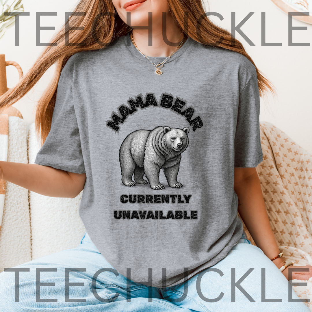 A woman wearing a gray graphic t-shirt with a black and white print of a bear and the text 'MAMA BEAR CURRENTLY UNAVAILABLE'.