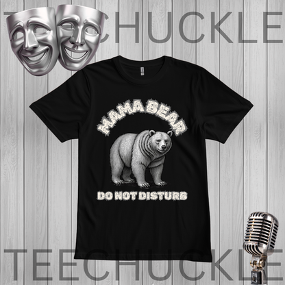 A black short-sleeve graphic t-shirt featuring a white and gray illustration of a bear with the text 'MAHA BEAR DO NOT DISTURB'. The t-shirt is displayed on a gray wood-plank background with a vintage microphone, theater masks