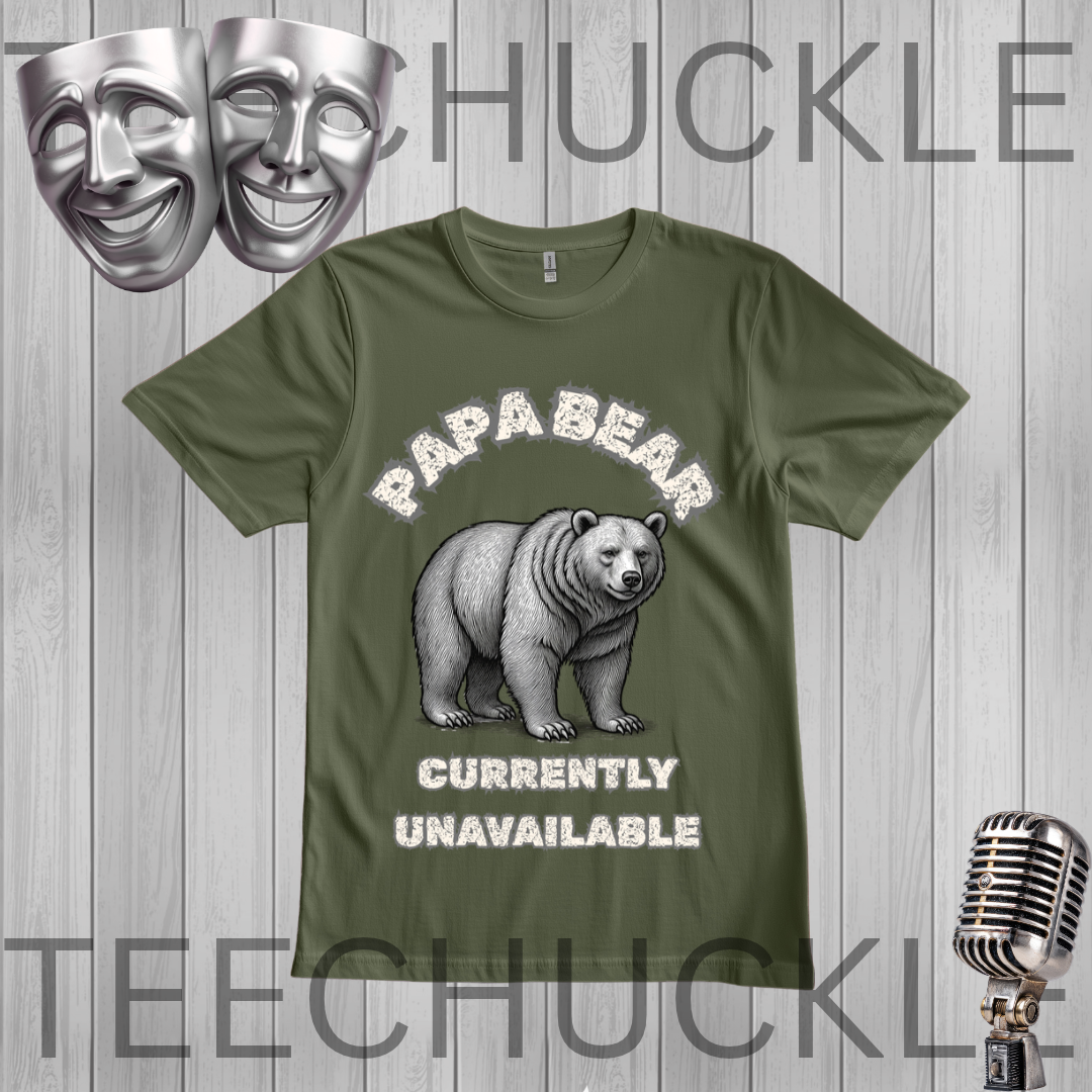 A green graphic t-shirt featuring a polar bear illustration and the text 'PAPA BEAR CURRENTLY UNAVAILABLE' in a distressed white font. The t-shirt is displayed on a gray wood-plank background with decorative props including a silver microphone, a comedy and tragedy mask