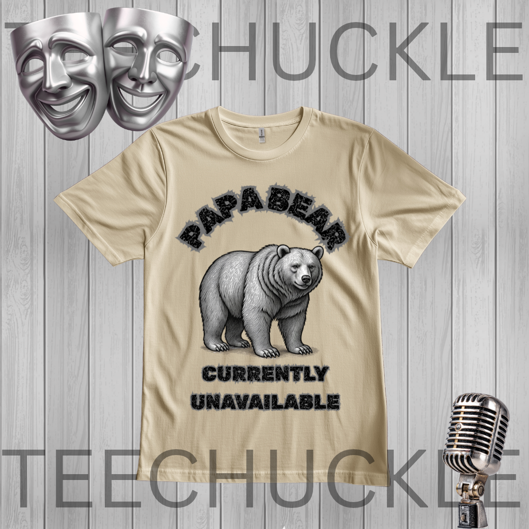 A sand graphic t-shirt featuring a polar bear illustration and the text 'PAPABEAR CURRENTLY UNAVAILABLE' in black. The t-shirt is displayed on a gray wood-plank background with decorative silver theater masks and a vintage microphone