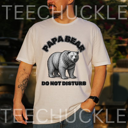 A man wearing a white graphic t-shirt with a black and gray print of a bear and the text 'PAPABEAR DO NOT DISTURB'. 