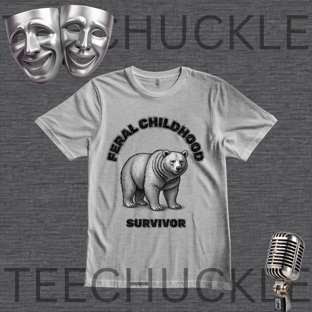 A light gray graphic t-shirt featuring a black and white illustration of a grizzly bear with the text 'FERAL CHILDHOOD SURVIVOR'. The t-shirt is displayed on a dark gray textured background with theatrical comedy and tragedy masks, a vintage microphone