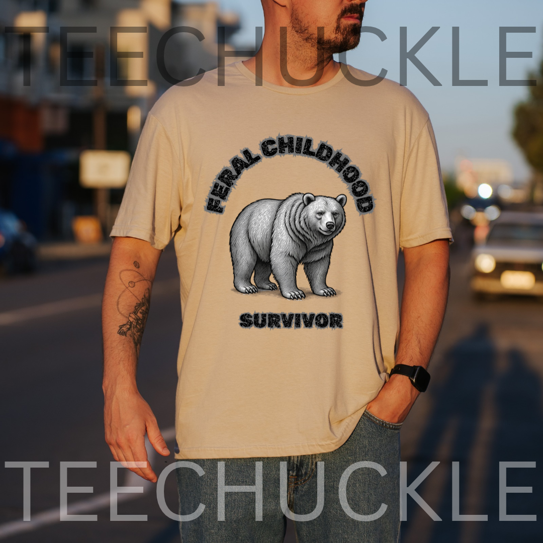 A man wearing a sand graphic t-shirt with a black bear illustration and the text 'FERAL CHILDHOOD SURVIVOR'. The background is a blurred street scene at dusk