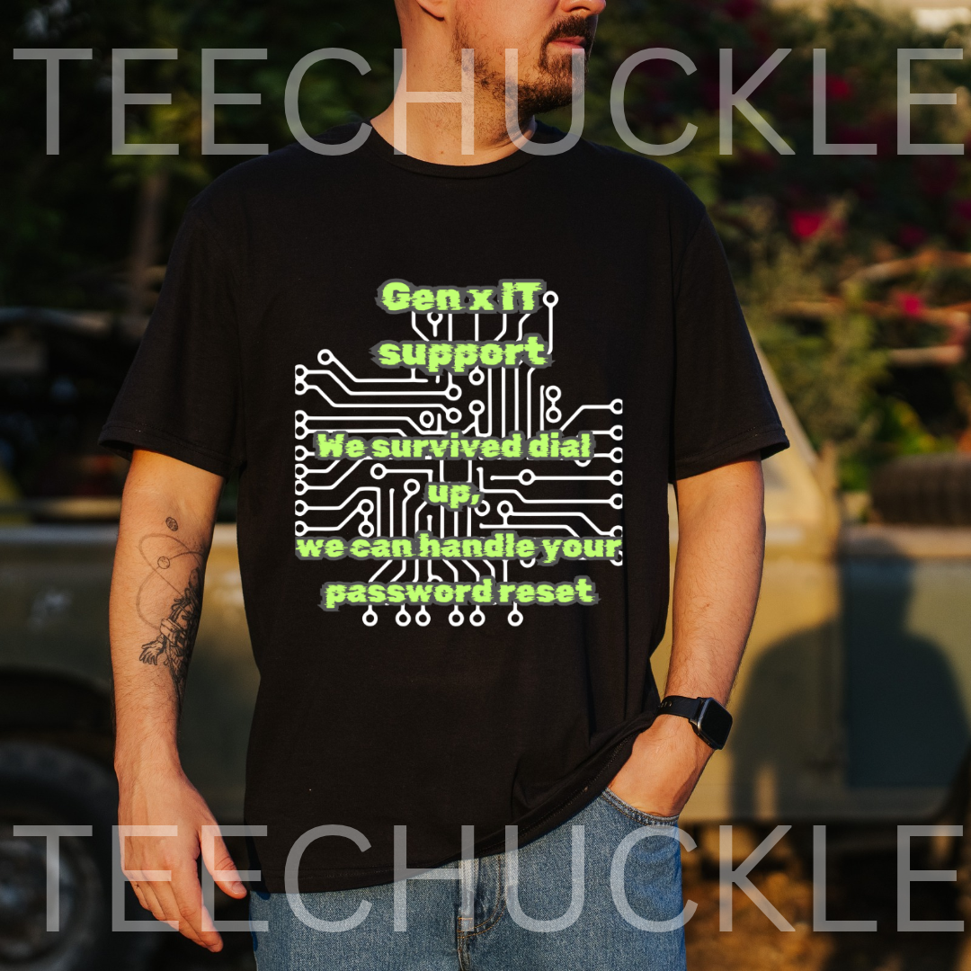 A man wearing a black graphic t-shirt with a green and white circuit board design and text that reads 'Gen x IT support Nosurfed dial 000 we can handle your password reset'. The background is an outdoor blurred setting with a car and trees
